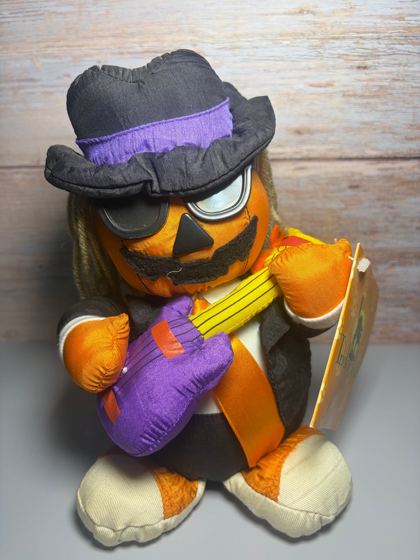 Peluche de calabaza cantante animada vintage: guitarra, sombrero fedora y gafas de sol, con etiqueta
